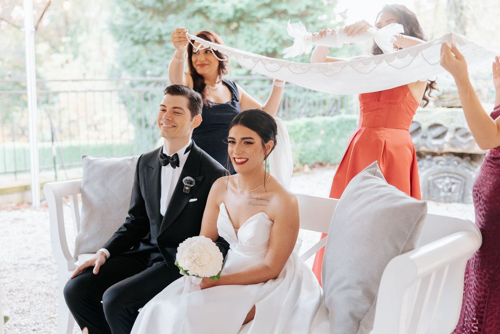Aghd ceremony moment — family holding the lace canopy over the smiling couple during a Persian wedding ceremony